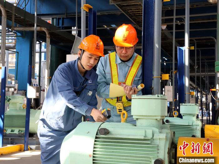 圖為齊魯石化員工巡檢監測運轉電機溫度，確保設備安穩運行。　劉芳芳 攝